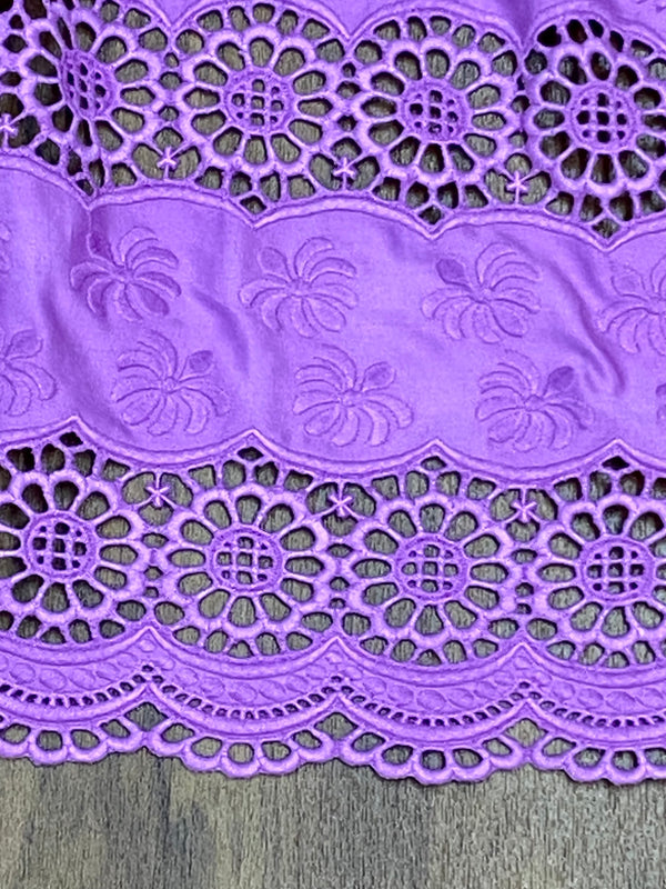 „Detailaufnahme Dirndlschürze violett mit aufwendiger Lochstickerei Bordüre“