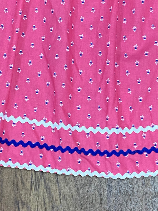 „Nahaufnahme, Rosa Vintage Dirndl-Schürze  mit Blumenmuster, Zierborten in Weiß und Blau