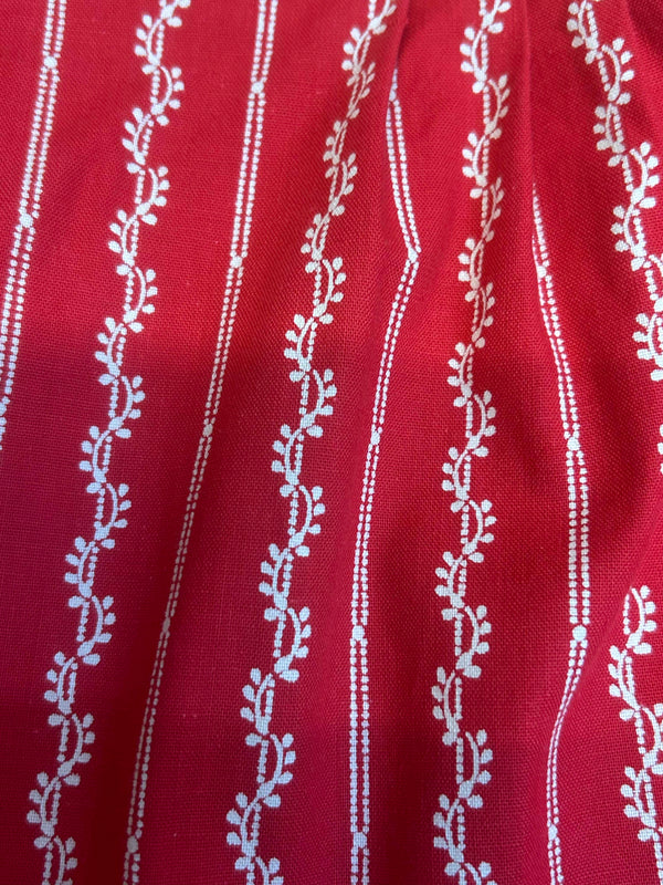 „Detail Stoff rote Trachten Schürze mit Ornamentstreifen Baumwolle“