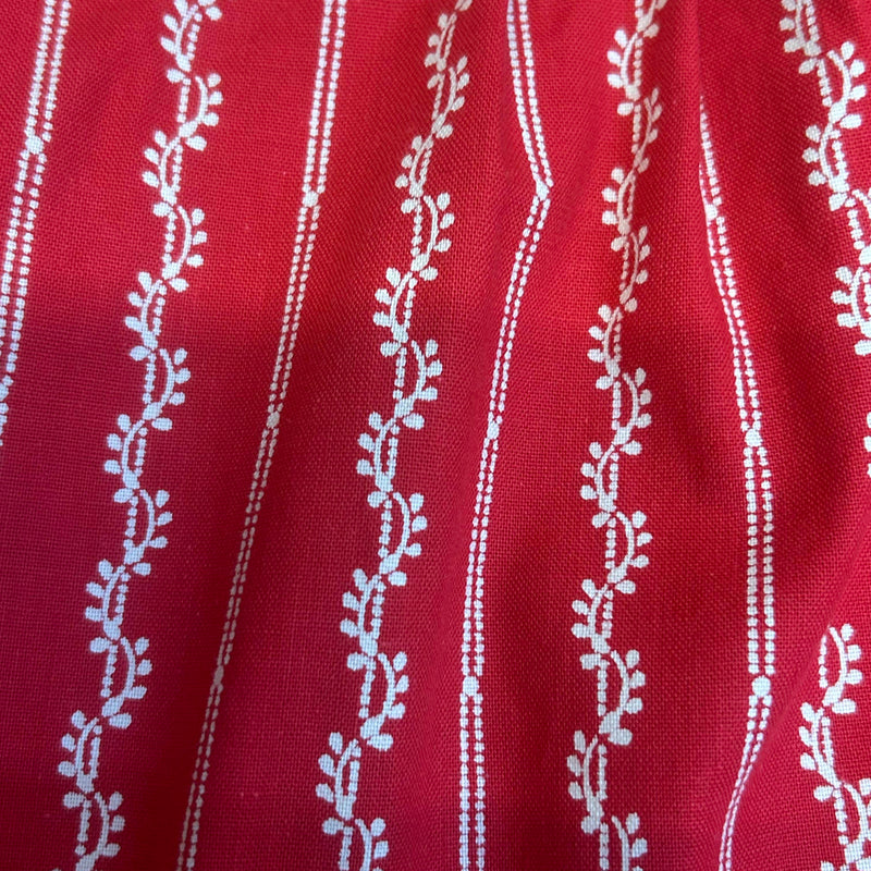 „Detail Stoff rote Trachten Schürze mit Ornamentstreifen Baumwolle“