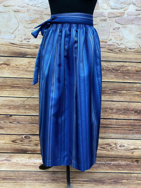 Dirndlschürze aus Baumwolle in Blau mit weißen Streifen, Länge 85 cm, Vintage, auf Holzboden ausgebreitet.