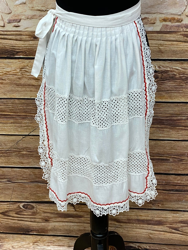 „Vintage Dirndl-Schürze in Weiß mit roter Ziernaht und Spitzenrand, Länge 59 cm“