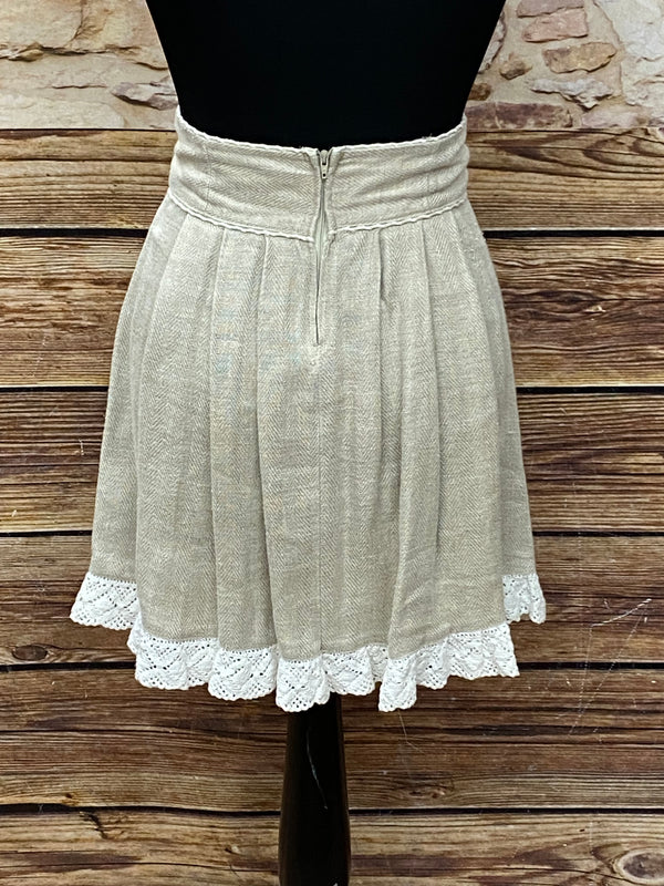 „Rückseite des beigen Trachtenrocks in Größe 34 mit hohem Bund und Klöppelspitze am Saum“