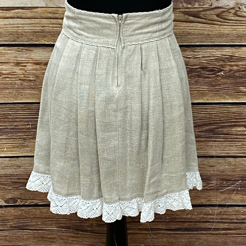 „Rückseite des beigen Trachtenrocks in Größe 34 mit hohem Bund und Klöppelspitze am Saum“