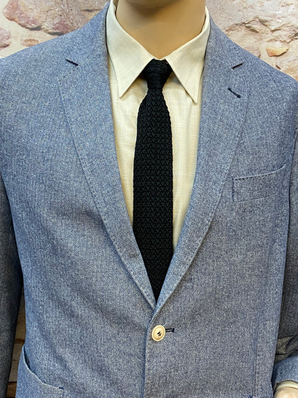 Detailansicht Revers, hellbeiges Hemd und schwarze Strickkrawatte des grauen Slim-Fit-Anzugs