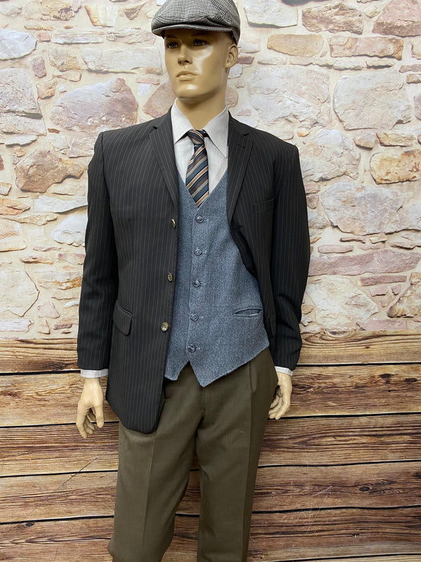 „Outfit mit geöffnetem Sakko – graue Weste und gestreifte Krawatte im 20er-Jahre-Stil.“