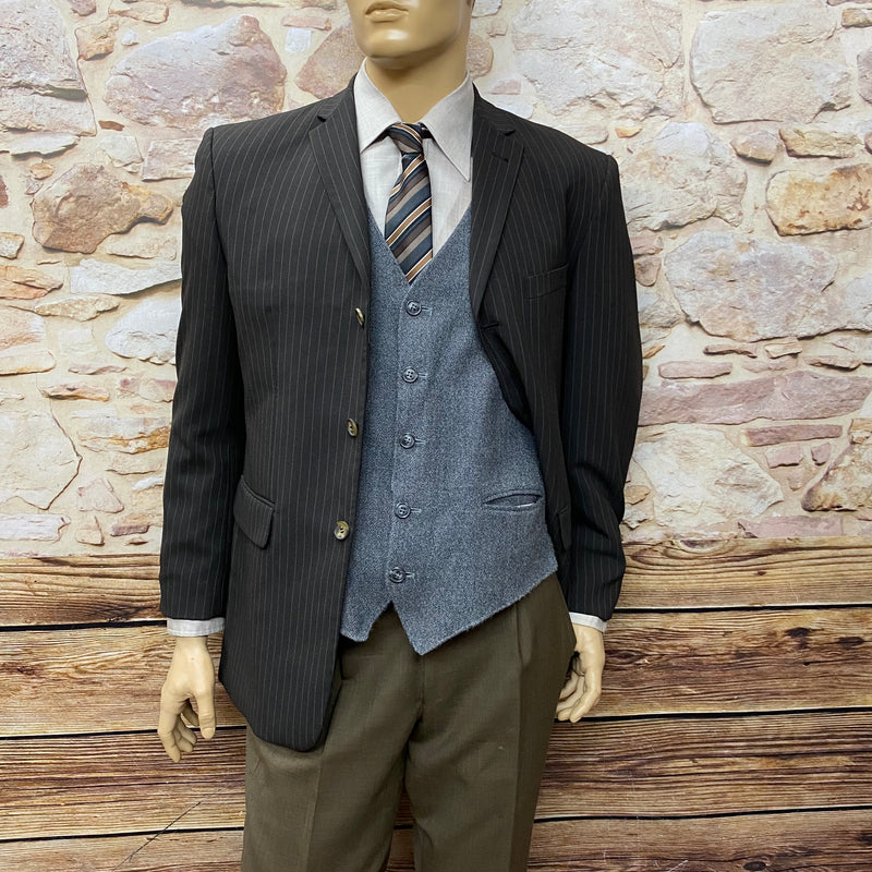 „Outfit mit geöffnetem Sakko – graue Weste und gestreifte Krawatte im 20er-Jahre-Stil.“