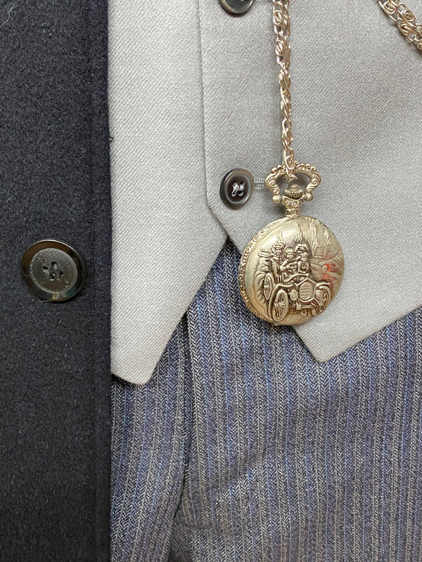 „Detail der silbernen Taschenuhr an der grauen Weste – Deko, nicht im Lieferumfang enthalten.“
