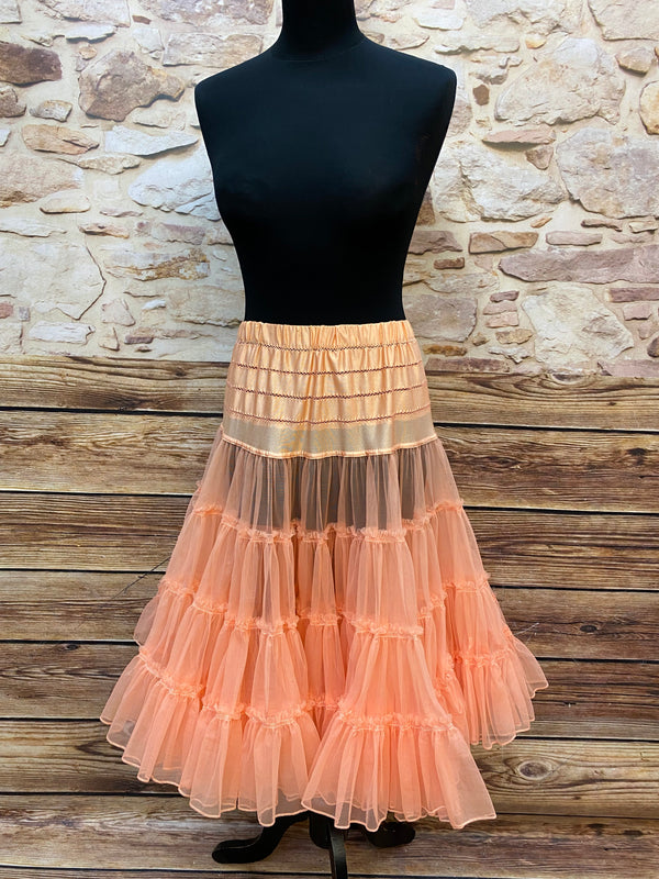 „Apricotfarbener Petticoat in Tellerweite auf schwarzer Schneiderpuppe, weich fallend und füllig, Länge etwa 65 cm.