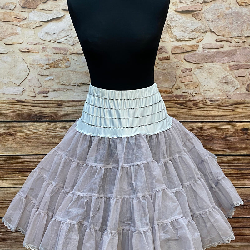 „Grauer, fülliger Vintage-Petticoat in Größe 38–42 auf Schneiderpuppe, tellerweit und zweilagig mit Spitzenkante.“