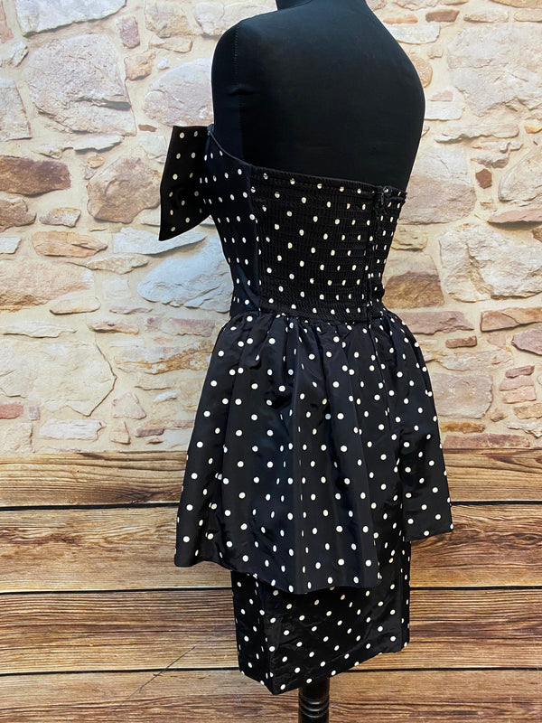 „Seitliche Ansicht vom schwarzen gepunkteten Rockabilly Kleid mit Schößchen und trägerlosem Schnitt“