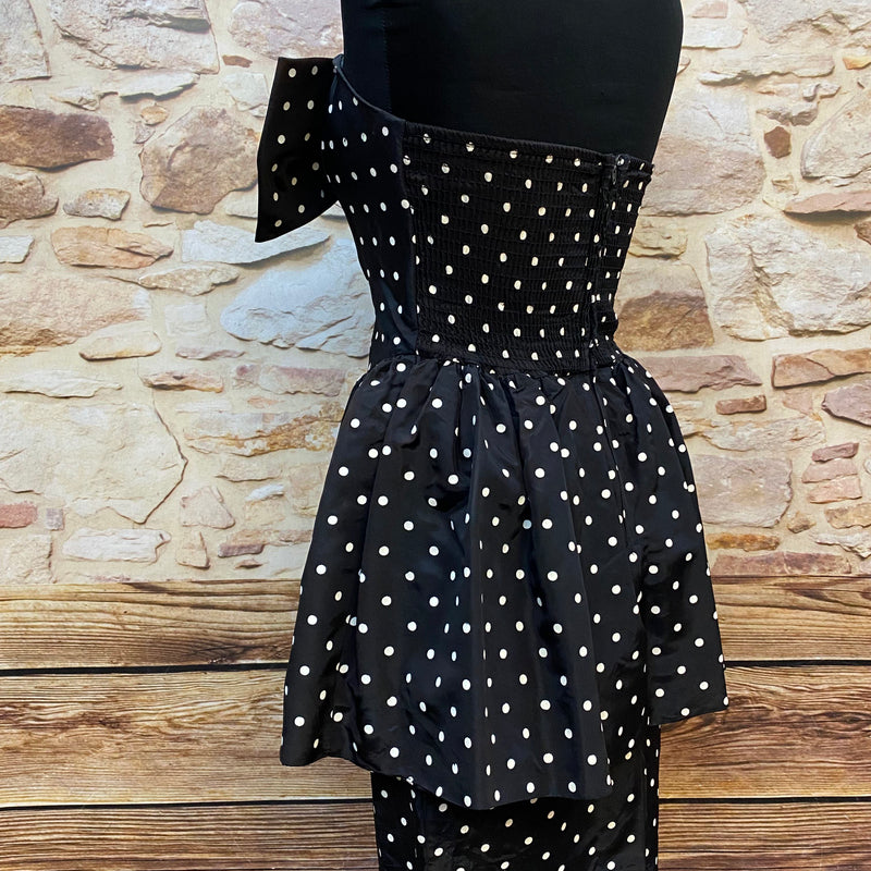 „Seitliche Ansicht vom schwarzen gepunkteten Rockabilly Kleid mit Schößchen und trägerlosem Schnitt“
