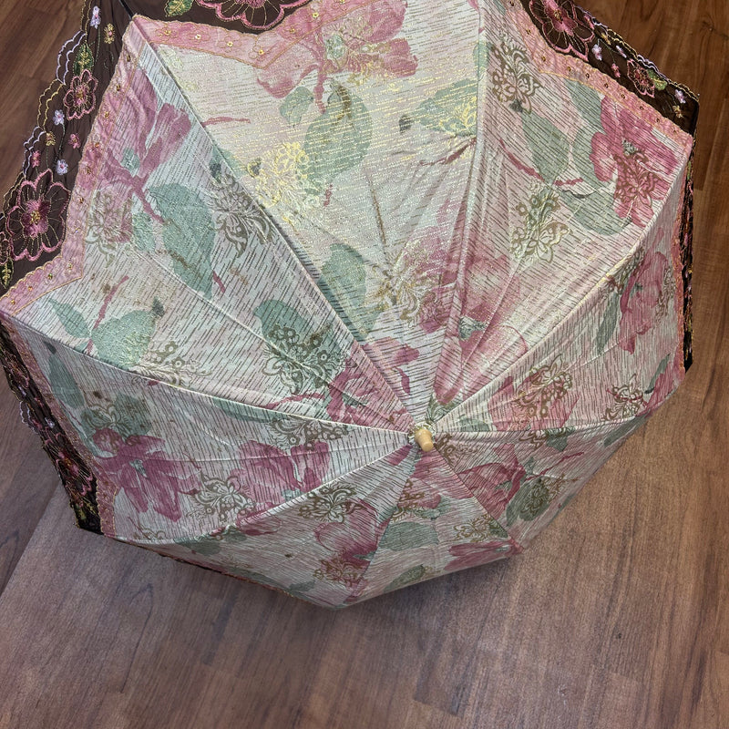 „Geöffneter Vintage-Schirm mit Blumenmuster und besticktem Spitzenrand in Schwarz und Gold“