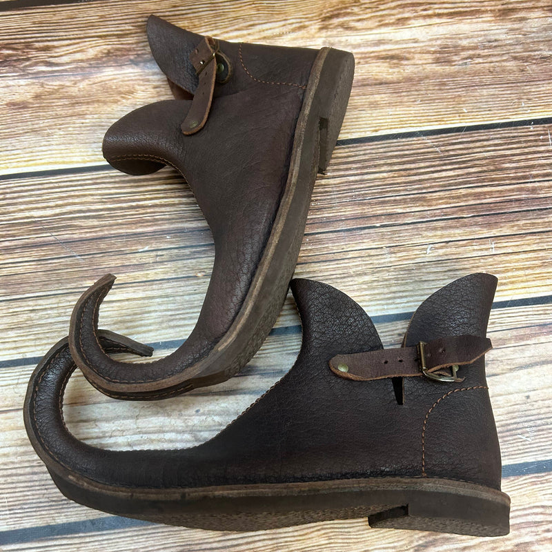 „Seitenansicht handgearbeitete Schnabelschuhe mit gebogener Spitze und Schnalle“