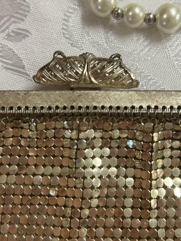 „Detailaufnahme vom Verschluss der silberfarbenen Vintage-Abendtasche im Jugendstil-Design“