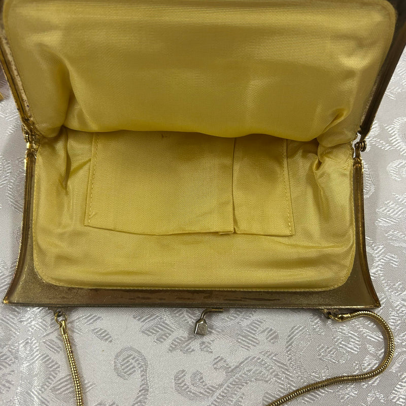 Innenansicht einer goldfarbenen Vintage-Abendtasche mit Satinfutter.