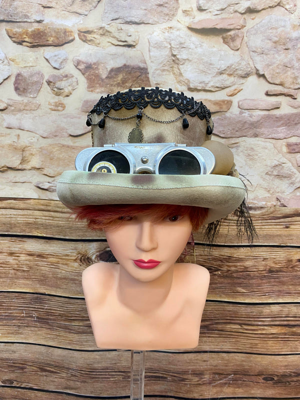 Handveredelter Steampunk Damen-Zylinder in Beige mit Goggles, schwarzer Feder, Spitze, Ketten und Metallornamenten, Unikat Gr. 56/57