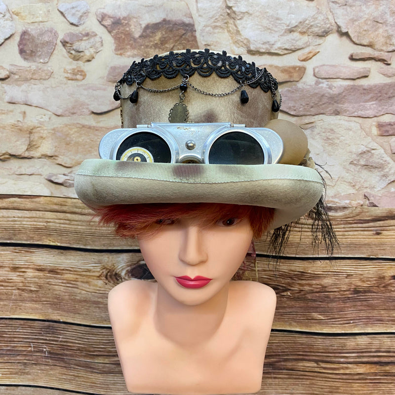Handveredelter Steampunk Damen-Zylinder in Beige mit Goggles, schwarzer Feder, Spitze, Ketten und Metallornamenten, Unikat Gr. 56/57