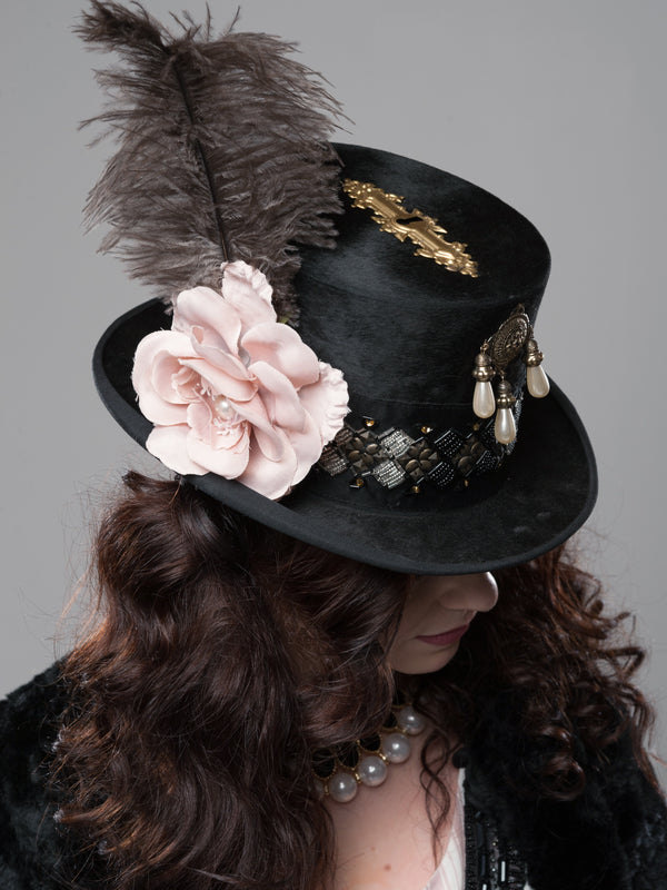Handveredelter Steampunk-Zylinder Gr. 57 mit Feder, roséfarbener Blüte und messingfarbenen Applikationen.
