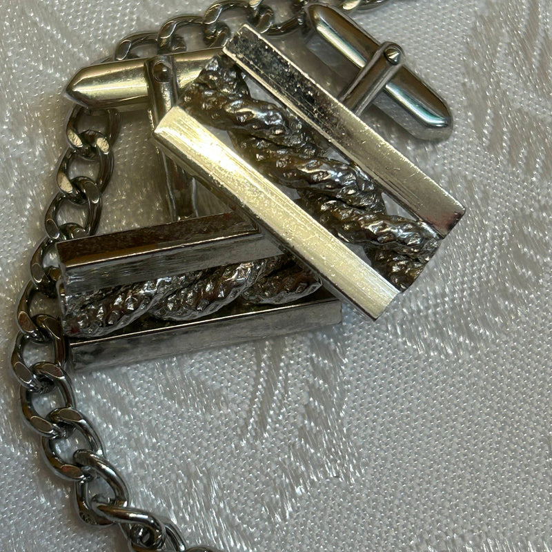 „Detailaufnahme Manschettenknöpfe mit Ornamentstruktur in Silber“