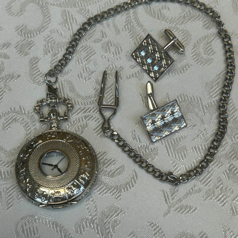 „Taschenuhr-Set mit Kette und Manschettenknöpfen auf weißem Stoff“