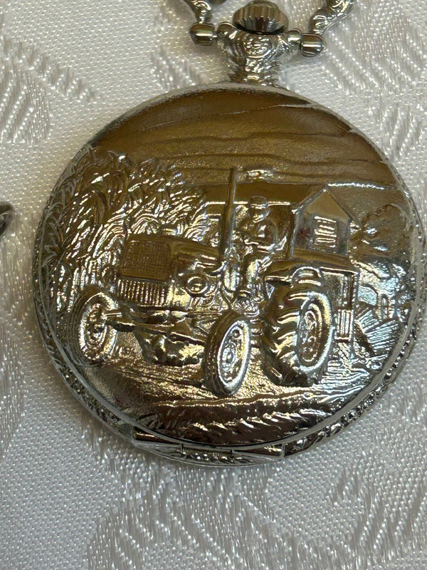 „Detailaufnahme Traktor-Relief auf Taschenuhrdeckel, silberfarben glänzend“