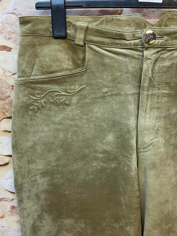 Detail einer olivgrünen Trachten-Lederhose mit floraler Stickerei und Knopf