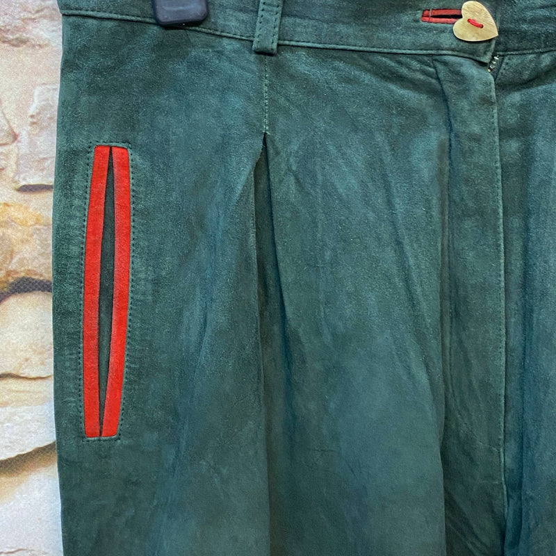 Detail einer dunkelgrünen Damen Lederhose mit rotem Akzent und Herzknopf