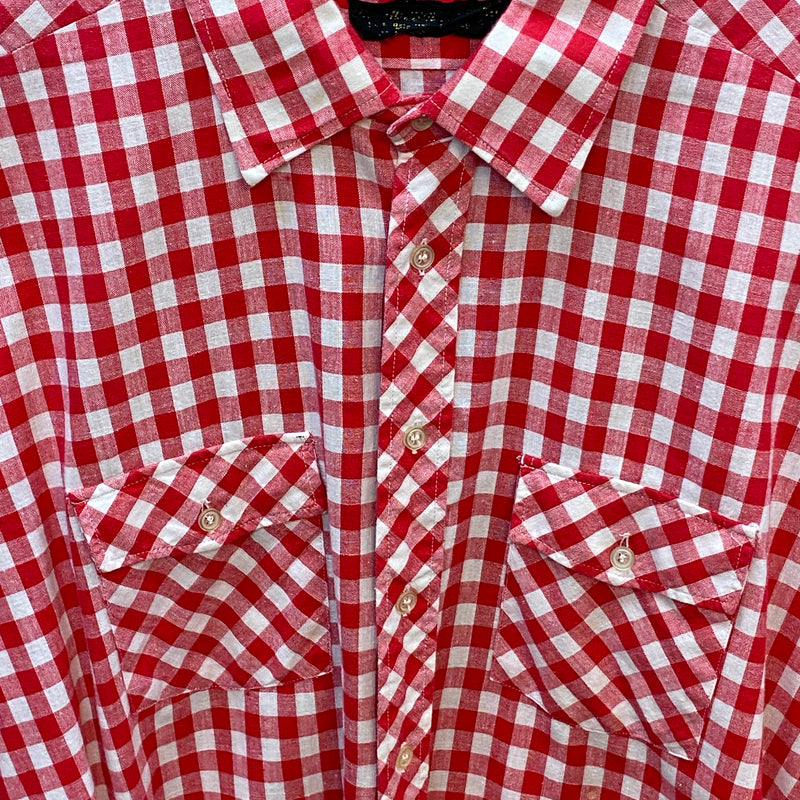 „Detailansicht eines rot-weiß karierten Vintage Trachtenhemds Herren mit diagonal gemusterten Brusttaschen“