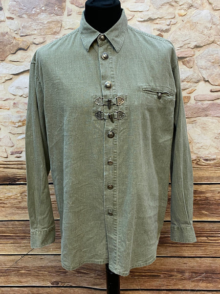 Alttext
„Olivgrünes Trachtenhemd mit Metallschnallen und Brusttasche auf Schneiderpuppe“