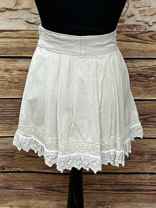 „Rückansicht des beigen Trachtenrocks mit Spitzenbesatz am Saum“