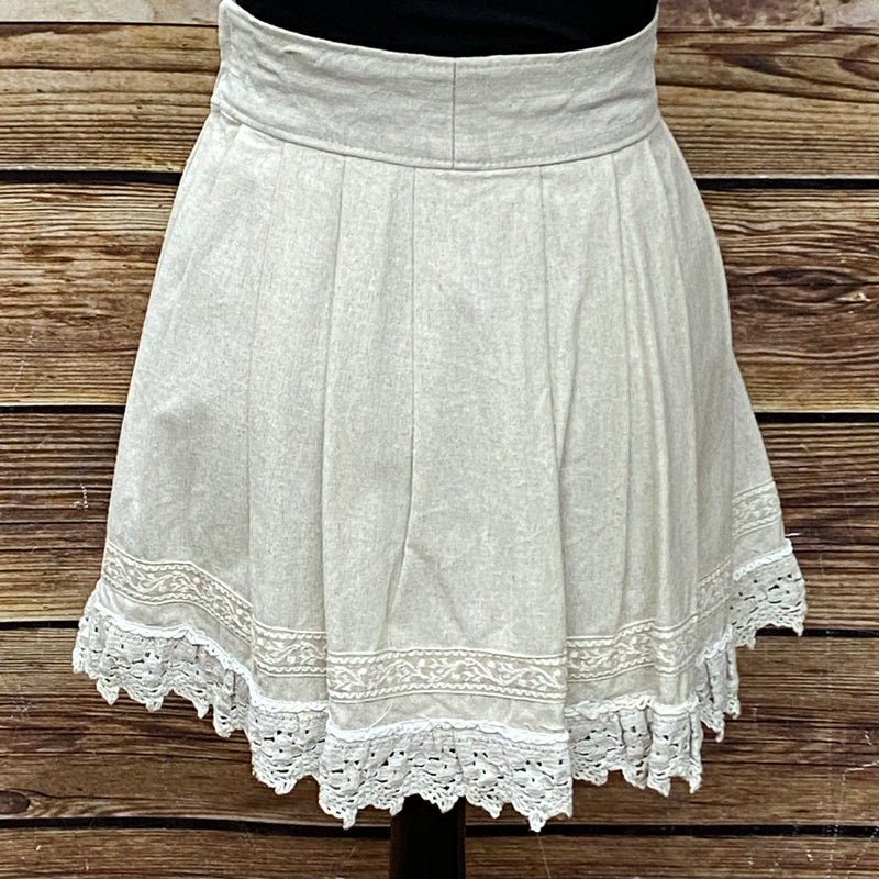 „Rückansicht des beigen Trachtenrocks mit Spitzenbesatz am Saum“