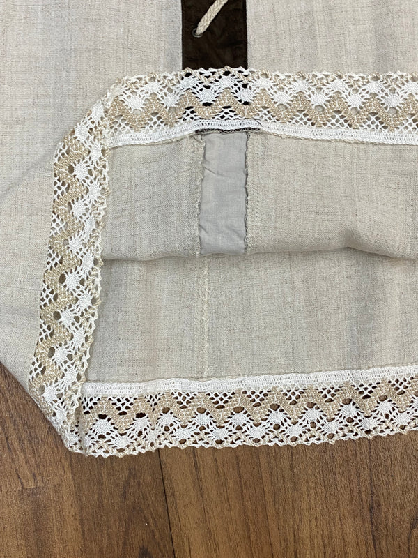 „Detail Klöppelspitze am Saum des Trachtenrocks, Leinenmischgewebe“