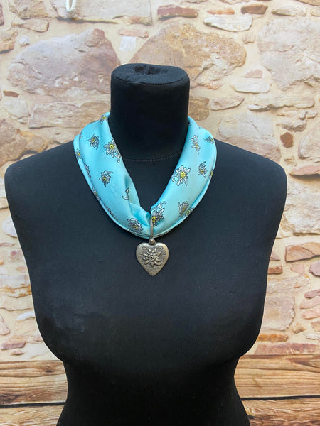 „Türkises Trachtentuch mit Edelweiß-Muster und silbernem Herz-Anhänger im alpenländischen Stil“