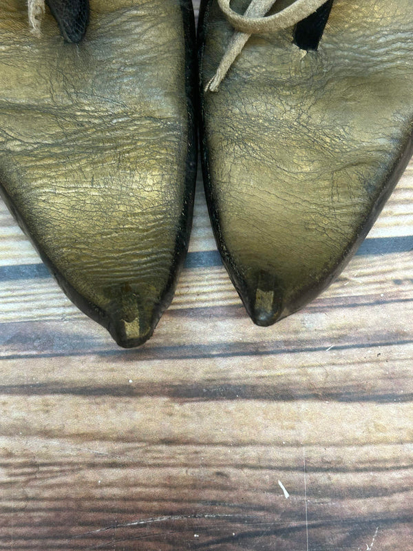 „Detailaufnahme der spitzen Schuhfront bei Unikat Schnabelschuhen in Goldoptik“