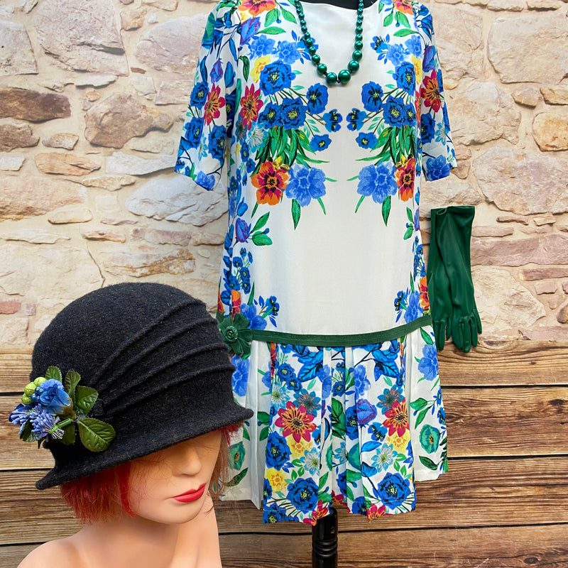 „20er Jahre Tageskleid Größe 40 mit buntem Blumenmuster, schwarzem Cloche-Hut, grünen Handschuhen und Perlenkette“