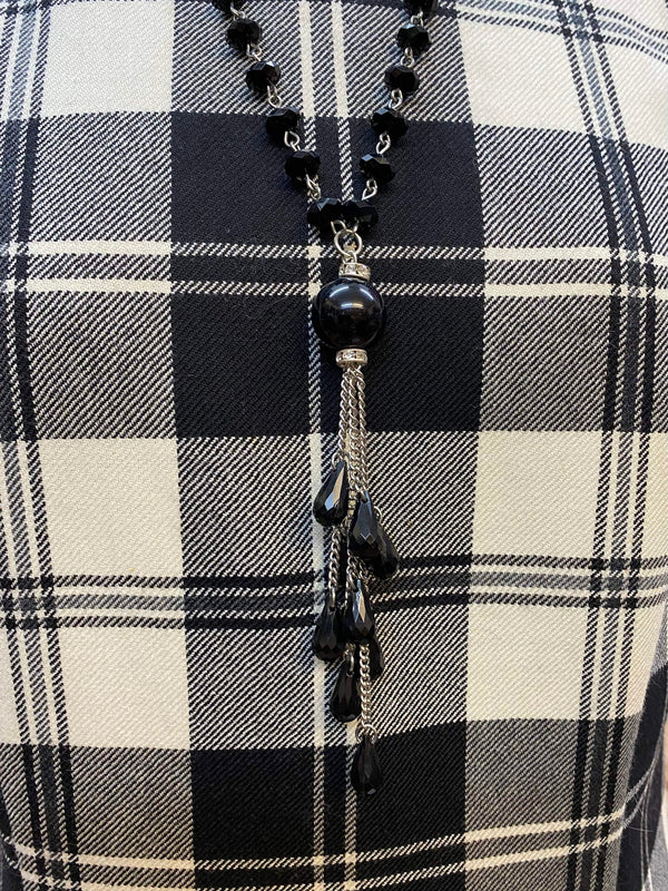 „Schwarze Handschuhe und Kette als Accessoires zu elegantem Vintage Tageskleid im 20er Jahre Stil“