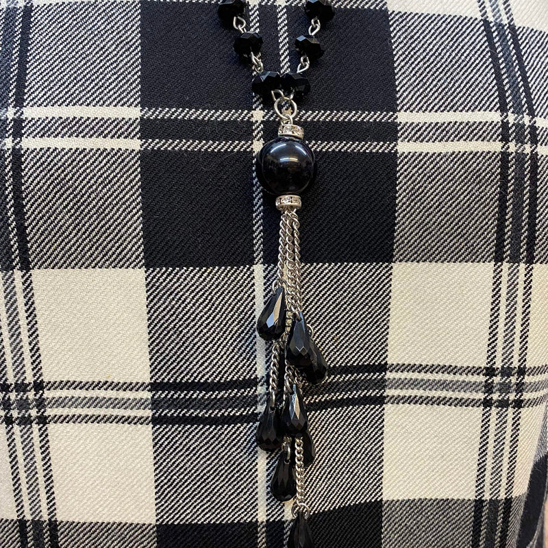 „Schwarze Handschuhe und Kette als Accessoires zu elegantem Vintage Tageskleid im 20er Jahre Stil“