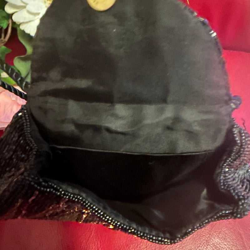 „Innenansicht der Abendtasche mit schwarzem Futter und Druckknopfverschluss“