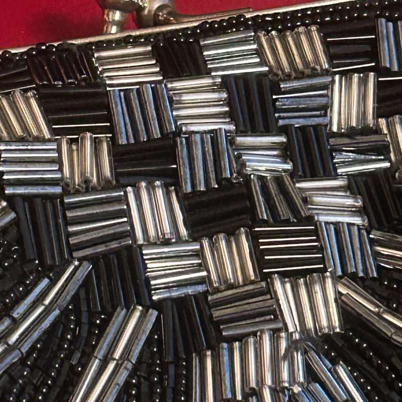 „Detailansicht des geometrischen Musters aus Glasperlen in Schwarz und Silber“