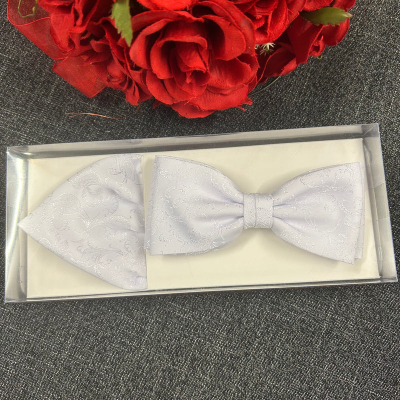 Weißes Fliegen- und Einstecktuch-Set in Geschenkbox mit roten Rosen im Hintergrund