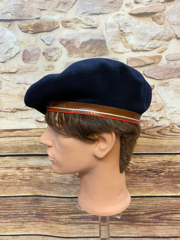 „Seitliche Ansicht von dunkelblauem Vintage Barett mit braunem Rand und roter Zierlinie“