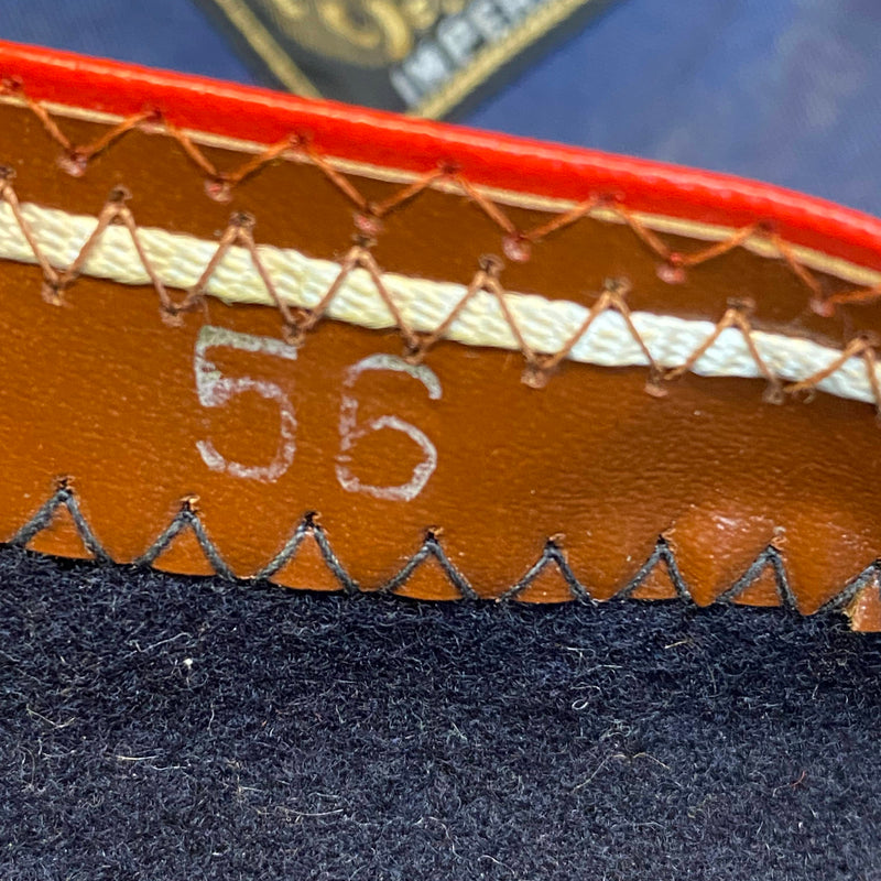„Detailaufnahme vom Größenaufdruck 56 im dunkelblauen Vintage Barett mit braunem Innenrand“