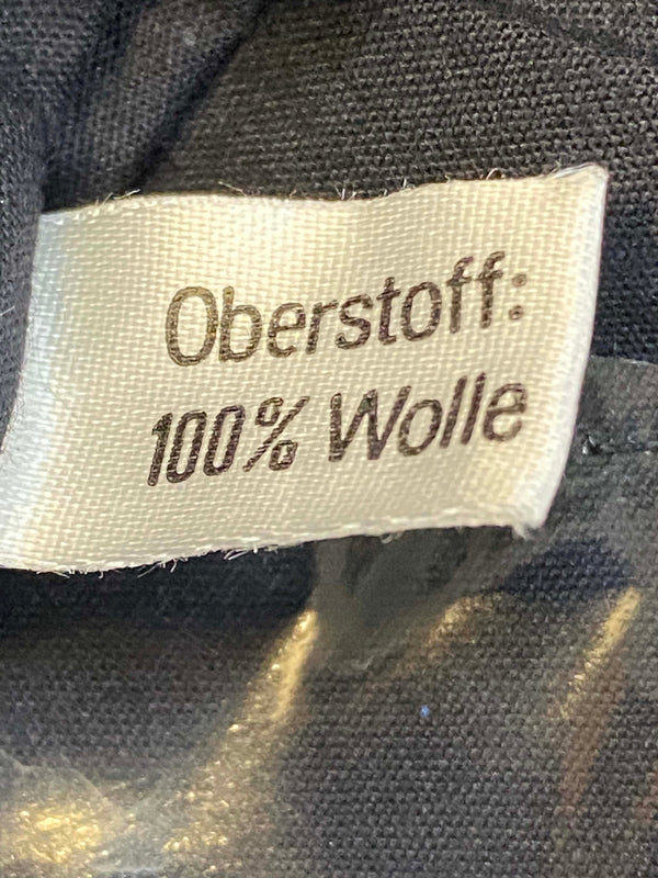 „Etikett mit 100 Prozent Wolle in grünem Vintage Uniform-Barett“