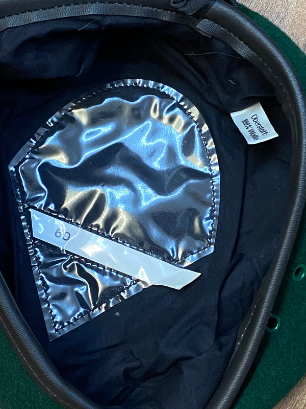 „Innenansicht eines grünen Vintage Uniform-Baretts Größe 60 mit dunklem Futter und Größenaufkleber“