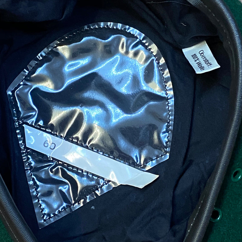 „Innenansicht eines grünen Vintage Uniform-Baretts Größe 60 mit dunklem Futter und Größenaufkleber“