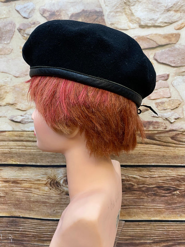 „Seitliche Ansicht von schwarzem Vintage Uniform-Barett mit Zugband und klassischer Barettform“