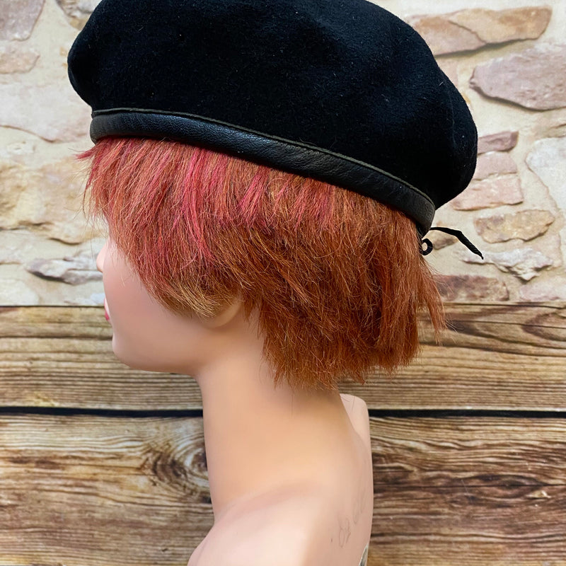 „Seitliche Ansicht von schwarzem Vintage Uniform-Barett mit Zugband und klassischer Barettform“