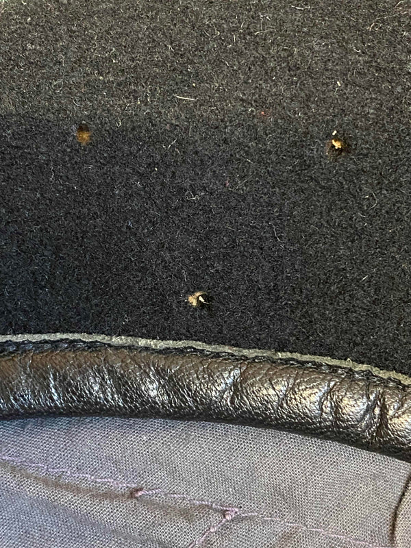 „Detailaufnahme vom schwarzen Vintage Uniform-Barett mit kleinen Spuren einer ehemaligen Abzeichenbefestigung“