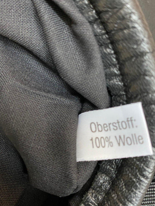 „Detailaufnahme vom Etikett Oberstoff 100 Prozent Wolle in blauem Vintage Uniform-Barett“